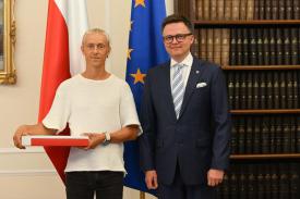 Marszałek Sejmu przekazał flagę RP ultramaratończykowi Romanowi Fickowi.